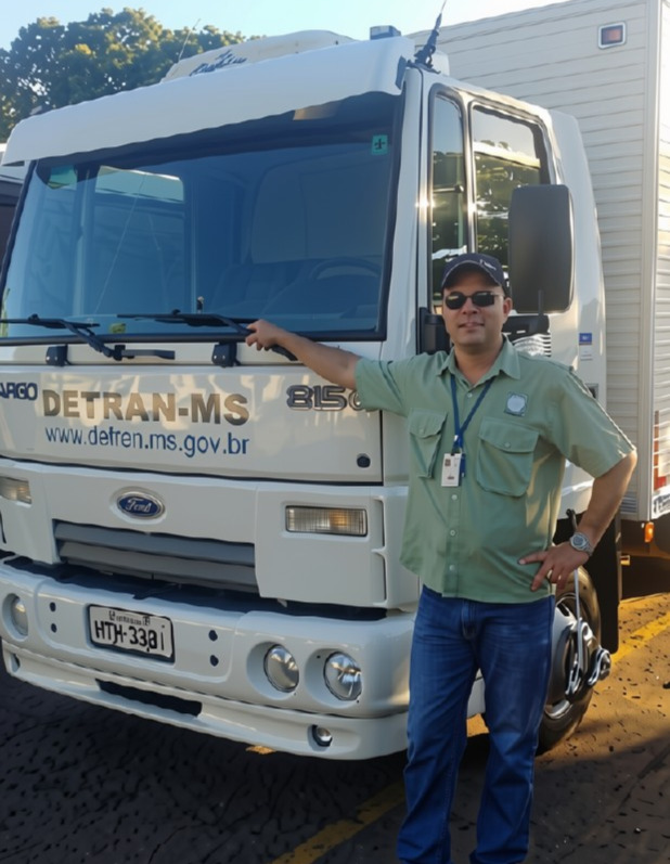 Servidor Kleber com um caminhão do Detran ao fundo